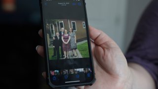 Jennifer Haugh shows a photo of her family from August 2015 before they left the Jehovah's Witnesses faith about a year later in 2016, at her home in York Haven, Pa.
