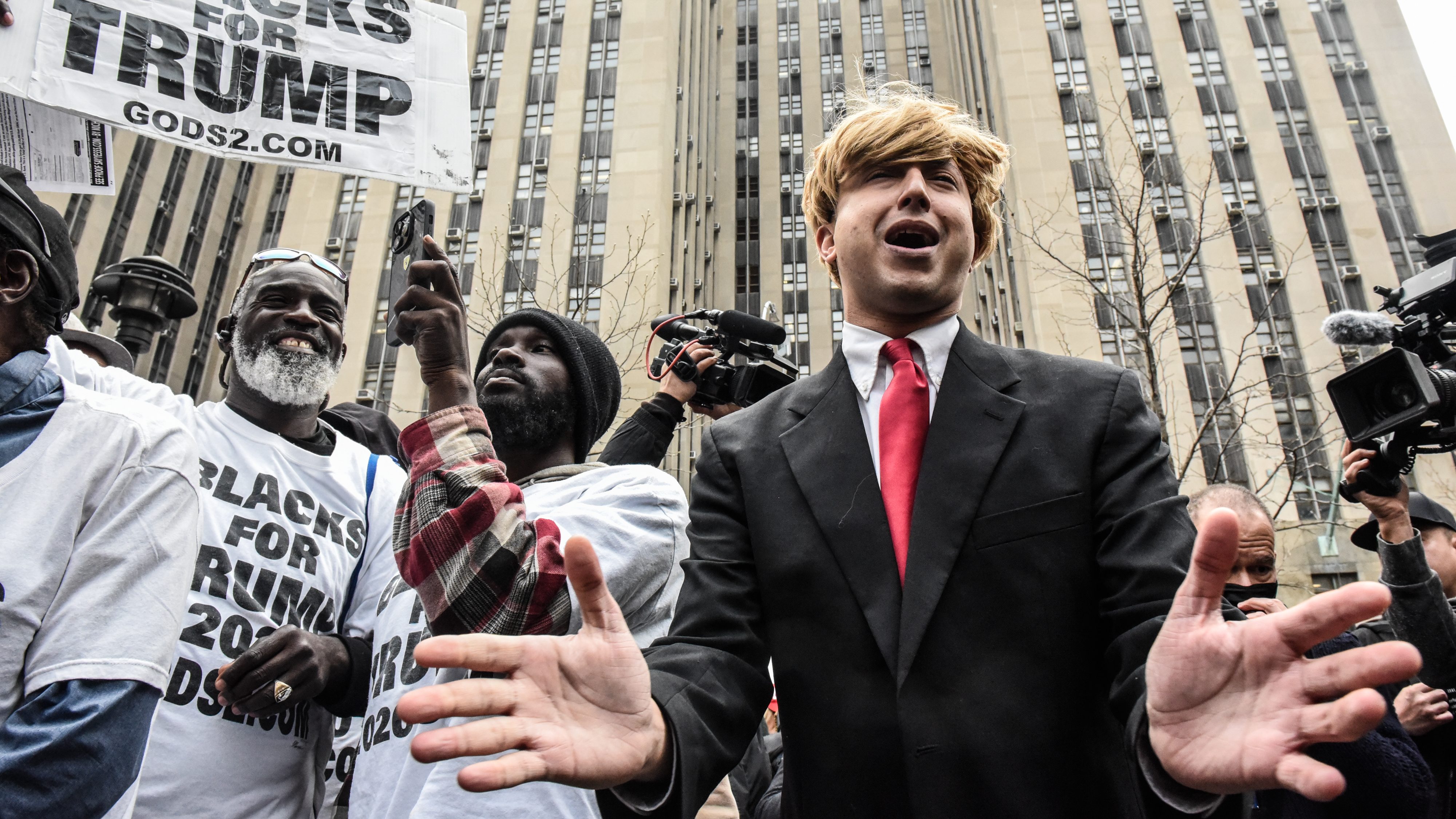 A protestor, center, next to supporters of former US President Donald Trump outside criminal court in New York.