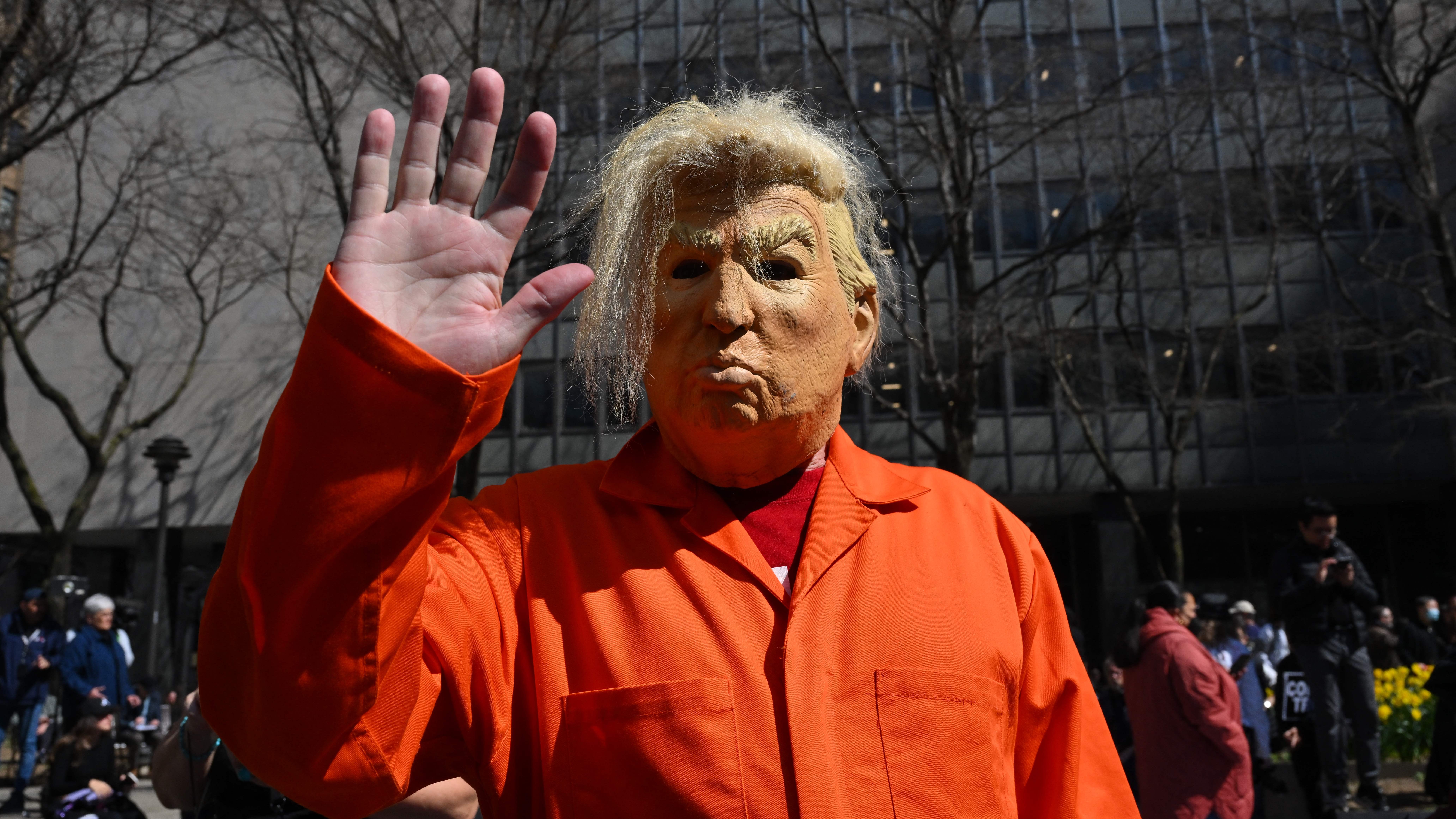 Person wears a Trump mask outside courthouse where hundreds gathered Tuesday.