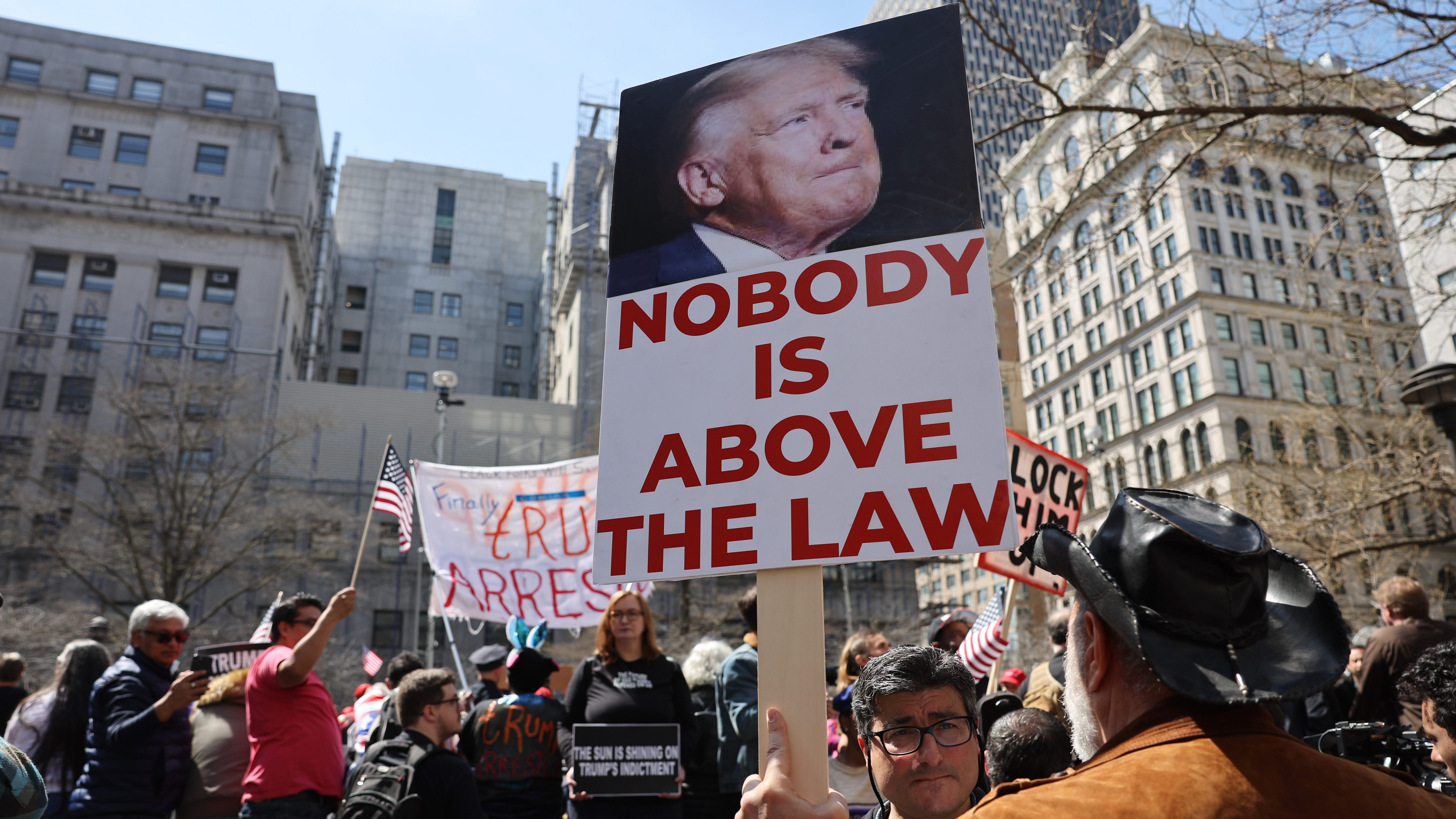 People protesting against former President Donald Trump gather outside of the Manhattan Criminal Court.