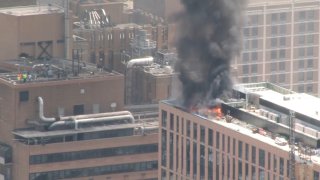 Black smoke and flames on top a Philadelphia high-rise.