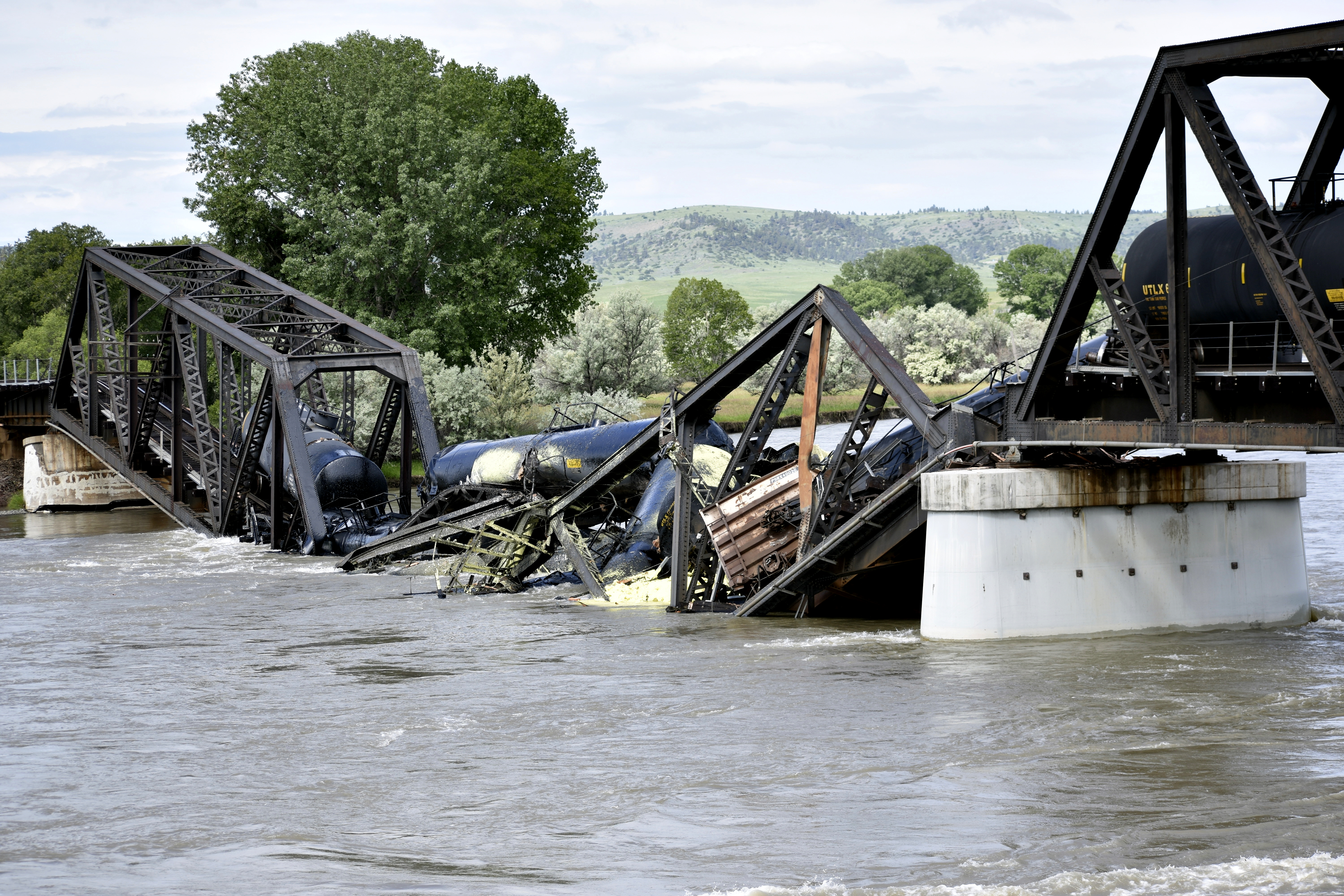 Several train cars are immersed in the Yellowstone River after a bridge collapse near Columbus, Mont., on Saturday, June 24, 2023.  