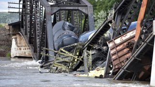 Several train cars are immersed in the Yellowstone River after a bridge collapse near Columbus, Mont., on Saturday, June 24, 2023.