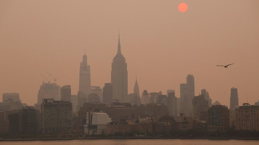 JERSEY CITY, NJ – JUNE 6: The sun is shrouded as it rises in a hazy, smokey sky behind the Empire State Building, One Vanderbilt and the Chrysler Building in New York City on June 6, 2023, as seen from Jersey City, New Jersey.