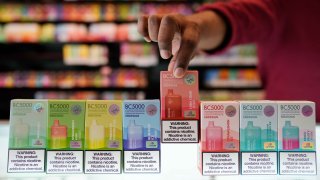 An employee displays some of the varieties of disposable electronic cigarette devices manufactured by EB Design, formerly known as Elf Bar, at Vapes N Smoke in Pinecrest, Fla., Monday, June 26, 2023.