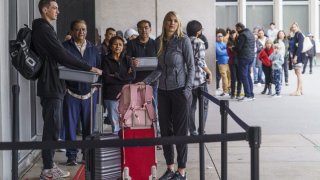 Marni Larsen and her son, Damon Rasmussen of Holladay, Utah, wait their turn in line hoping to snag her son’s passport outside the Los Angeles Passport Agency at the Federal Building in Los Angeles on Wednesday, June 14, 2023.  Larsen applied for her son’s passport two months earlier and spent weeks checking for updates online or through a frustrating call system. (AP Photo/Damian Dovarganes)