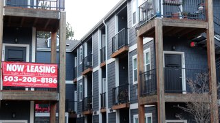 A ‘Now Leasing’ sign hangs off an apartment building staircase in southeast Portland, Ore., Dec. 9, 2021.