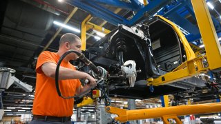 An emloyee works on the assembling of a brake caliper for an electric vehicle in Dueren, western Germany.