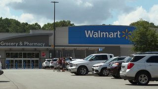 In this image taken from video, shoppers load purchased items into their vehicle Monday, July 31, 2023, at a Walmart in Lincolnton, N.C., where police say migrant workers were intentionally hit by an SUV in the parking lot of the store a day earlier.