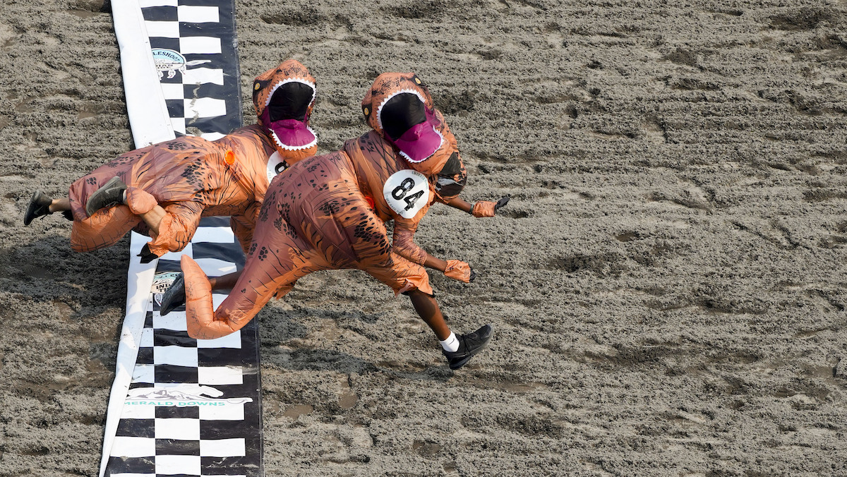 Dionte Gilbert (84) leaps across the finish line against Seth Hirschi, back, during the "T-Rex World Championship Races" at Emerald Downs, Sunday, Aug. 20, 2023, in Auburn, Wash. 