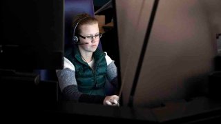 911 dispatch trainee Loren Bengston works at a computer in Denver on Oct. 20, 2022.