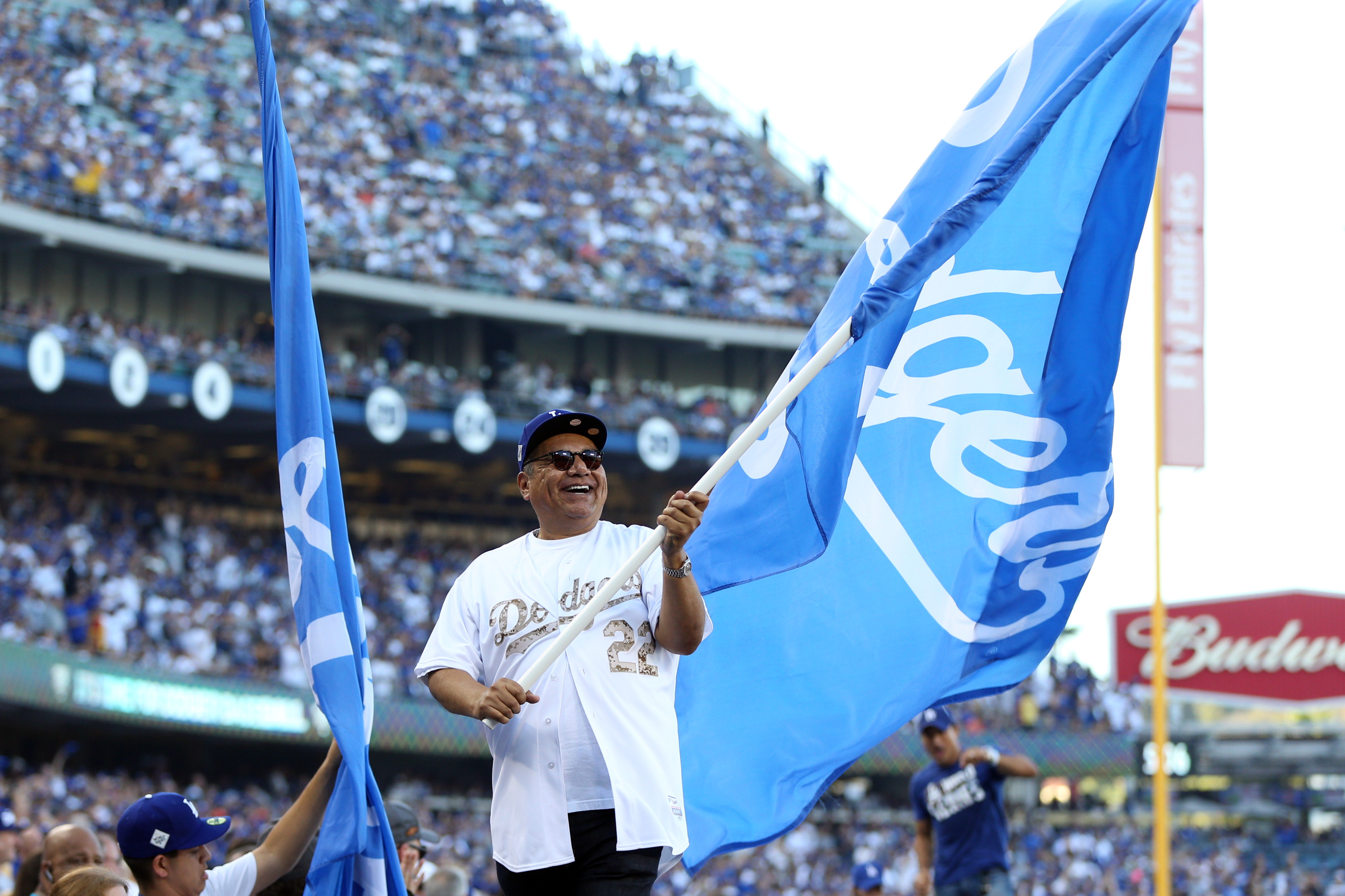 LOS ANGELES, CA - OCTOBER 24:  Actor George Lopez waves a Dodger flag on top of the dugout prior to Game 1 of the 2017 World Series between the Houston Astros and the Los Angeles Dodgers at Dodger Stadium on Tuesday, October 24, 2017 in Los Angeles, California. (Photo by Rob Tringali/MLB via Getty Images)