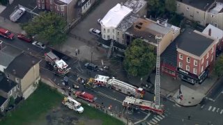 Aerial view of burned rowhome as fire crews work the scene.