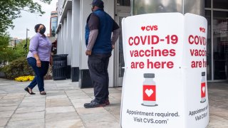 Signs offering COVID-19 vaccinations are seen outside of a CVS pharmacy in Washington, DC.