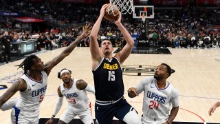 Nikola Jokic, #15 of the Denver Nuggets, shoots the ball against Bones Hyland, #5, and Norman Powell, #24, of the Los Angeles Clippers during the second half of a preseason game at Crypto.com Arena in Los Angeles on October 19, 2023.