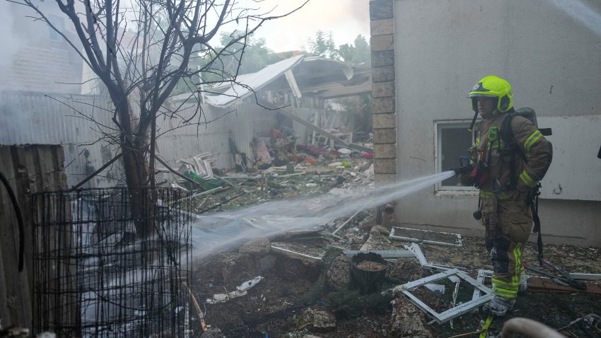 Israeli firefighters extinguish fire after a rocket fired from the Gaza Strip hit a house in Ashkelon, southern Israel, Saturday, Oct. 7, 2023. (AP Photo/Tsafrir Abayov)