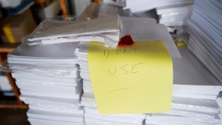 Stacks of paper too thick for Luzerne County's election equipment are seen in the county's warehouse in Wilkes-Barre, Pa., Wednesday, Sept. 13, 2023.