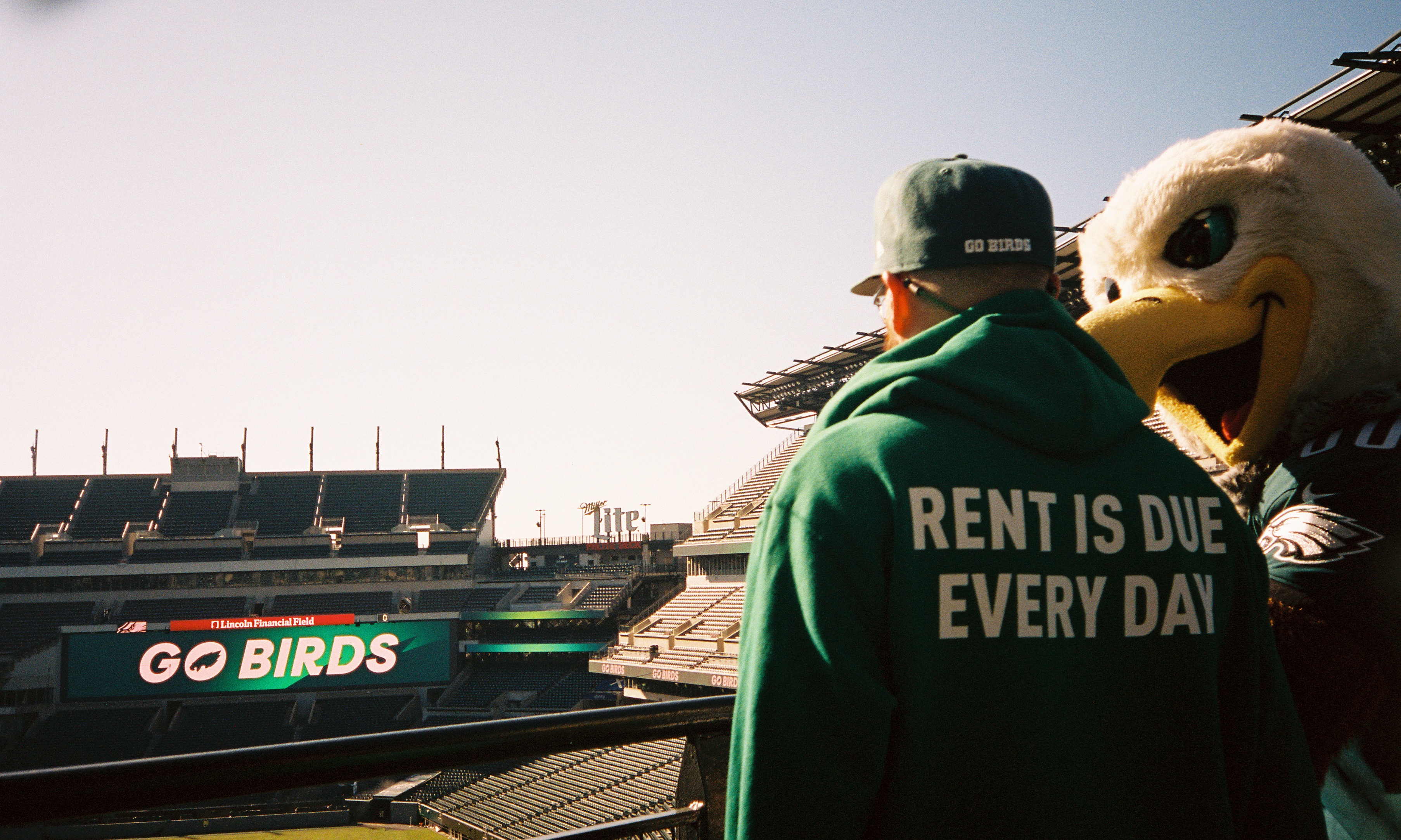 Guy in "rent is due everyday" sweatshirt with Eagles mascot Swoop.