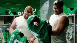 Landon Dickerson and Jordan Mialata hold kelly green Eagles jerseys.