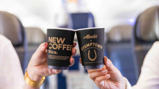 Two people cheers their Stumptown Coffee cups while sitting in an airplane