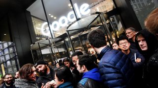 Workers stand outside the Google offices after walking out as part of a global protest over workplace issues, in London, England, on Nov. 1, 2018.
