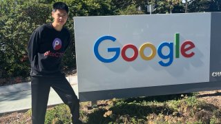 18-year-old software engineer Stanley Zhong, standing next to a Google sign.