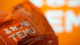 A package from Temu is seen in front of a screen with the Temu logo. (Photo by Nikos Pekiaridis/NurPhoto via Getty Images)