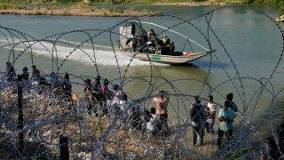 FILE – Migrants who crossed into the U.S. from Mexico are met with concertina wire along the Rio Grande, Sept. 21, 2023, in Eagle Pass, Texas.