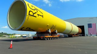 A huge foundation for an Orsted offshore wind turbine, called a monopile, sits atop wheeled movers in Paulsboro, N.J., July 6, 2023.
