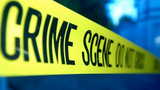Close-up on yellow crime scene tape over blue abstract background.