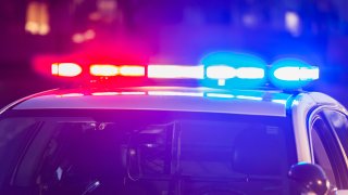 The roof of a police patrol car at night, with the blue and red lights flashing.