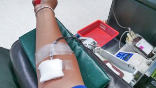 A life-saving blood donation in progress, capturing the selfless act of a donor's arm as blood flows through tubes into a collection bag, symbolizing hope and compassion.