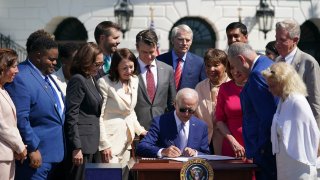 U.S. President Joe Biden, center, signs the CHIPS and Science Act of 2022 on the South Lawn of the White House in Washington, D.C., on Aug. 9, 2022.