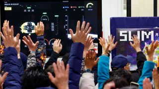 People raise their hands after a successful moon landing by the Smart Lander for Investigating Moon, in a public viewing event in Sagamihara, south of Tokyo, Japan, on Jan. 20, 2024.