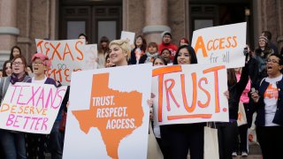 FILE – In this Feb. 26, 2015 file photo, college students and abortion rights activists hold signs during a rally on the steps of the Texas Capitol, in Austin, Texas.