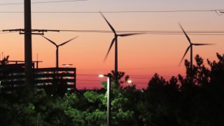 The sun sets behind spinning land-based wind turbines in Atlantic City, N.J. on Dec. 13, 2023. On Jan. 24, 2024,