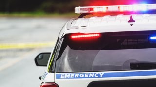 Police block a road on an emergency scene.