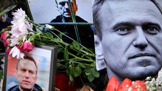 Flowers are seen placed around portraits of late Russian opposition leader Alexei Navalny, who died in a Russian Arctic prison, at a makeshift memorial in front of the former Russian consulate in Frankfurt am Main, western Germany, on February 23, 2024. 