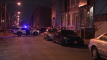Law enforcement officials investigate the scene after three people were hurt in a shooting at a house party in North Philadelphia early Sunday.