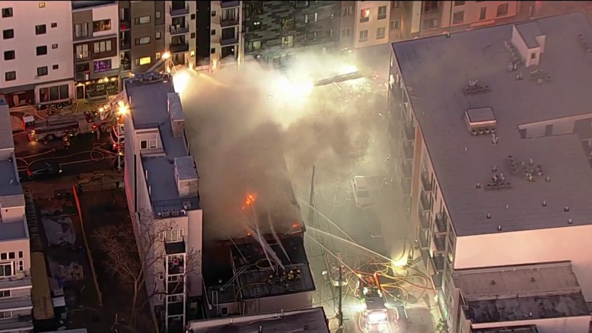 Residents evacuated as nearly 100 firefighters battle building fire in ...