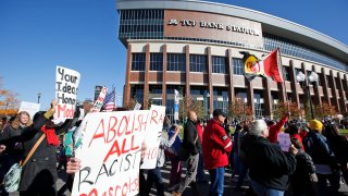 A "No Honor in Racism Rally" marches in front of TCF Bank Stadium before an NFL football game between the Minnesota Vikings and the Kansas City Chiefs, Oct. 18, 2015, in Minneapolis.