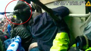 This image from police body-worn camera video, contained and annotated in the Justice Department’s sentencing memorandum against Michael Joseph Foy, shows Foy swinging his hockey stick as he lunges at the police line, at the U.S. Capitol on Jan. 6, 2021, in Washington.