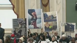 Kensington residents hold signs of featuring images of opioid addiction seen in the community at a City Council meeting on Feb. 8.