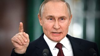 Russian President Vladimir Putin gestures while speaking at a news conference.