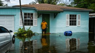 A man stands outside his flooded home after heavy rain in Fort Lauderdale, Florida, on April 13, 2023.