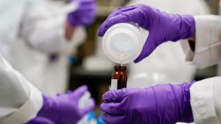 Eva Stebel, water researcher, pours a water sample into a smaller glass container for experimentation as part of drinking water and PFAS research at the U.S. Environmental Protection Agency Center For Environmental Solutions and Emergency Response on Feb. 16, 2023, in Cincinnati.