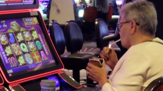 A gambler lights a cigarette at a slot machine in Harrah's casino in Atlantic City N.J. on Sept. 29, 2023.