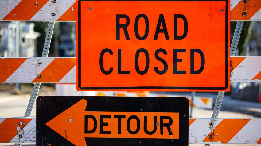 Road closed and detour signs w barrier up close