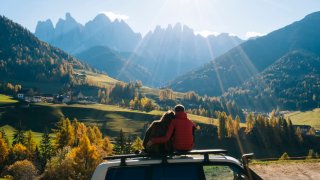 Couple admires mountain range. 