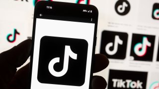 The TikTok logo is displayed on a mobile phone